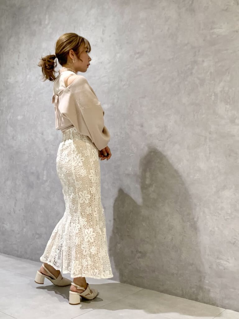 ホワイト系のスカート、ホワイト系のパンプス、ホワイト系のショルダーバッグを着用したレディースの春コーディネートの3枚目の写真