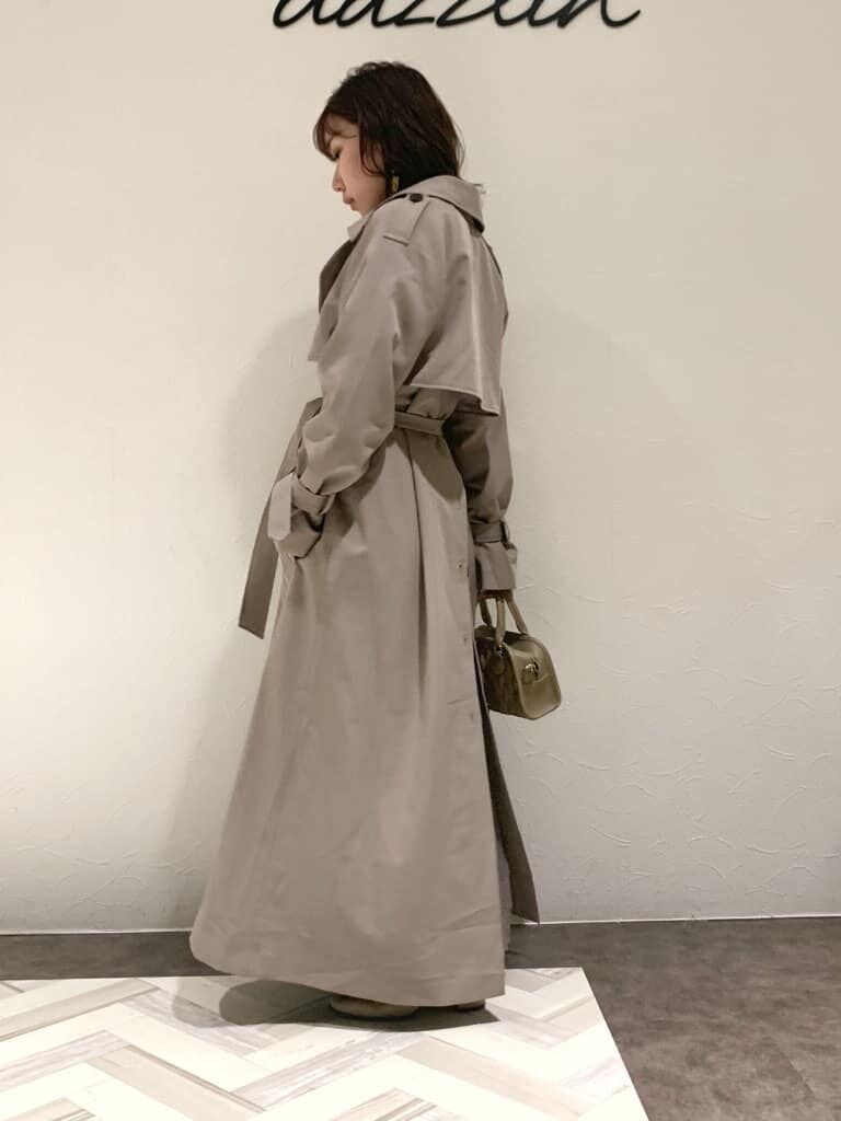 ブラウン系のワンピース、グレー系のトレンチコート、ベージュ系のハンドバッグを着用したレディースの秋コーディネートの10枚目の写真