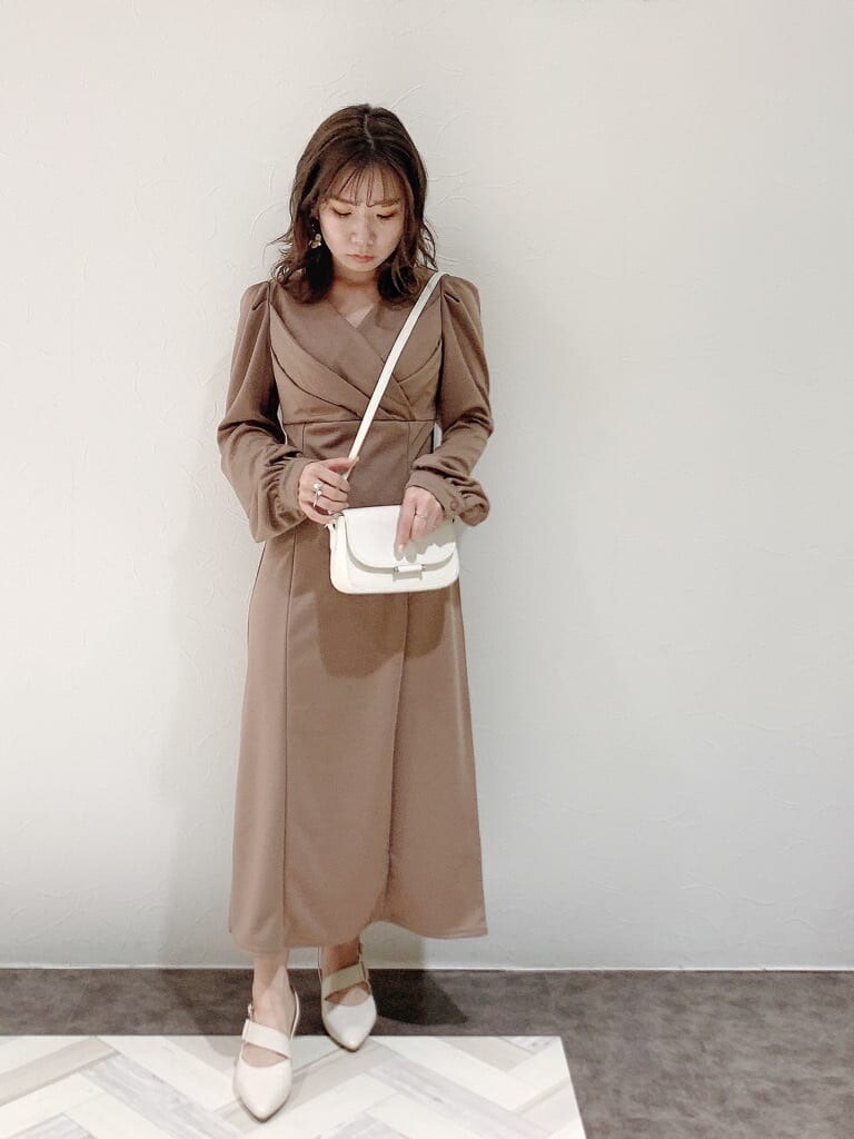 ブラウン系のワンピース、ホワイト系のパンプス、ホワイト系のショルダーバッグを着用したレディースの冬コーディネートの6枚目の写真