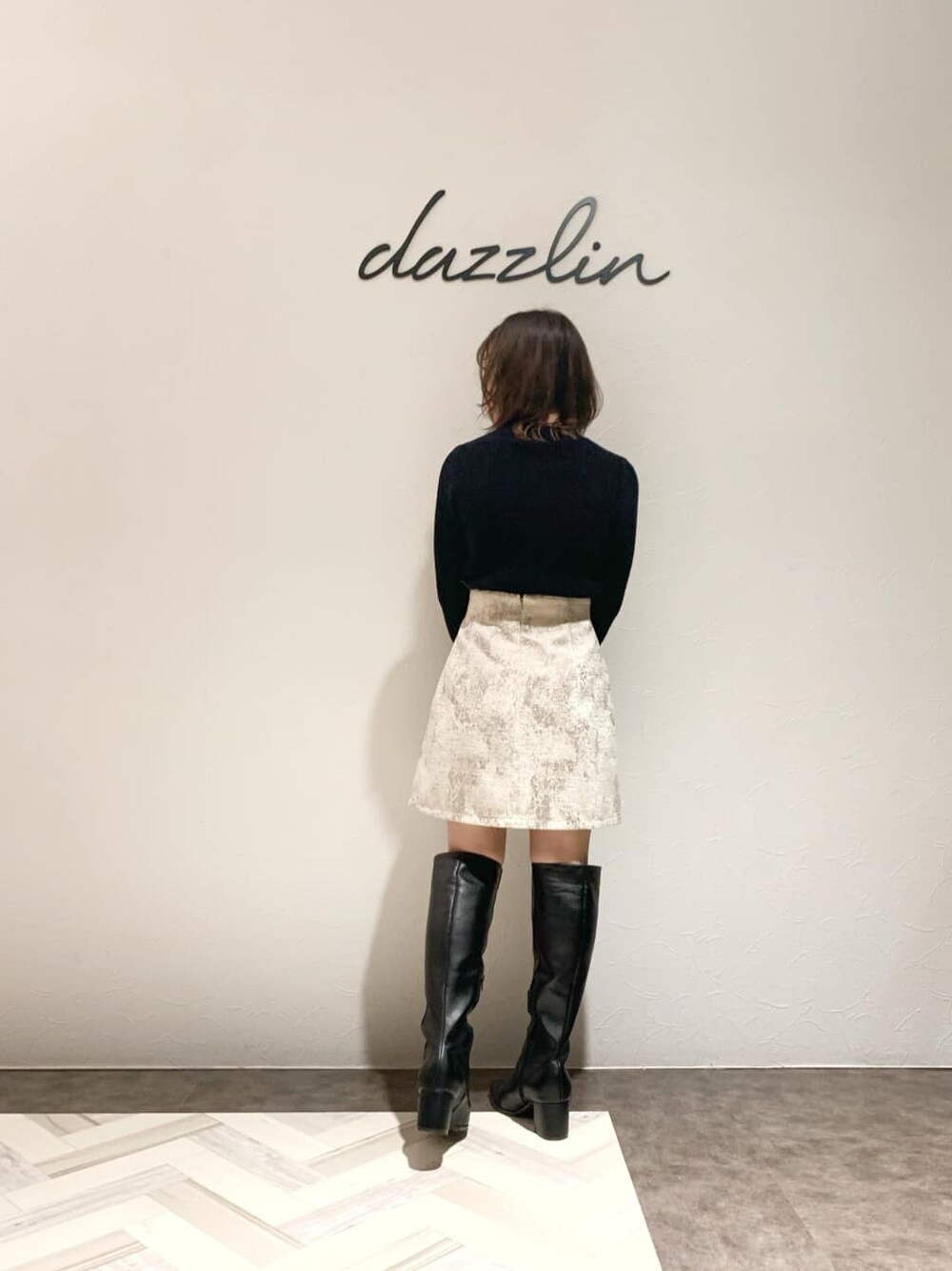 ベージュ系のスカート、ブラック系のブーツ、ブラック系のニット/セーターを着用したレディースの秋コーディネートの4枚目の写真