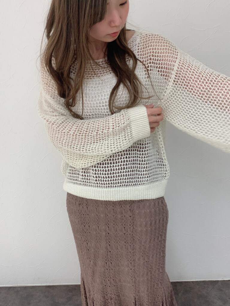 ベージュ系のスカート、ブラウン系のパンプス、ホワイト系のニット/セーターを着用したレディースの春コーディネートの4枚目の写真