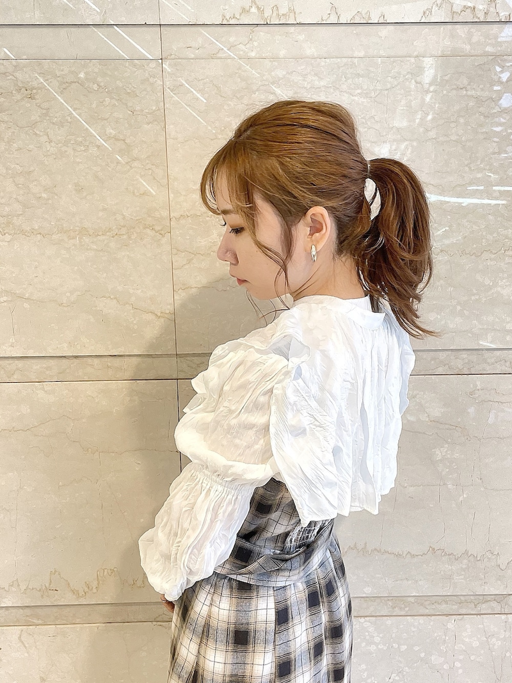 イエロー系のワンピース、グレー系のパンプスを着用したレディースの冬コーディネートの6枚目の写真