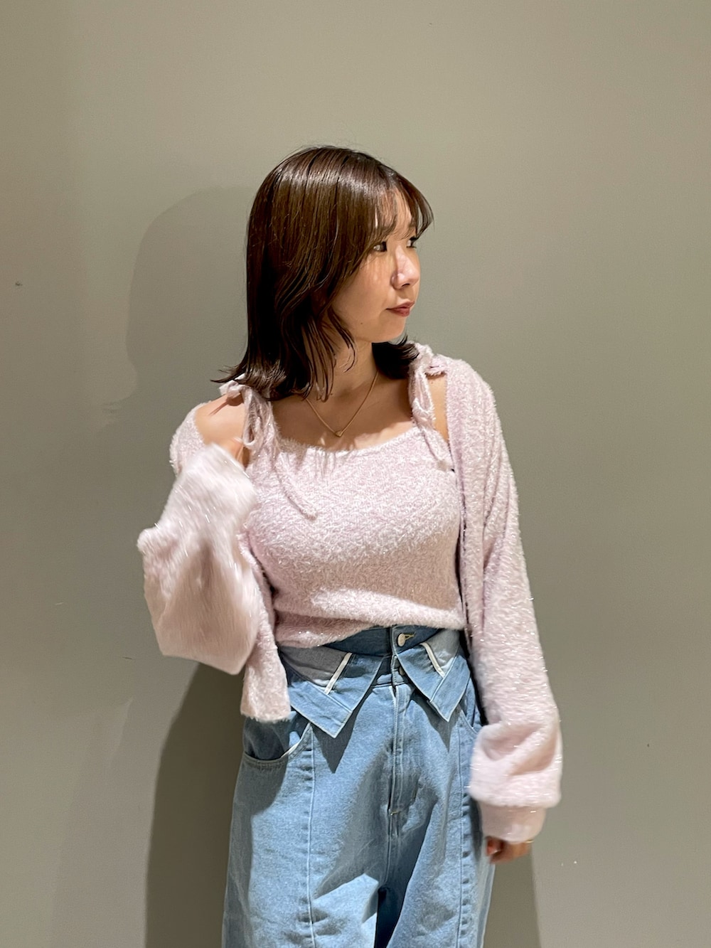 ピンク系のニット/セーター、ピンク系のカーディガン/ボレロ、ブルー系のデニムパンツを着用したレディースの秋コーディネートの4枚目の写真