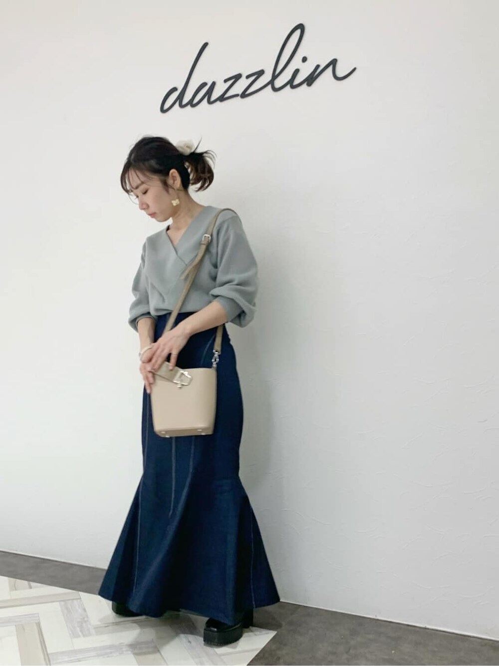 ブラック系のブーツ、ベージュ系のハンドバッグ、グリーン系のニット/セーターを着用したレディースの冬コーディネートの10枚目の写真