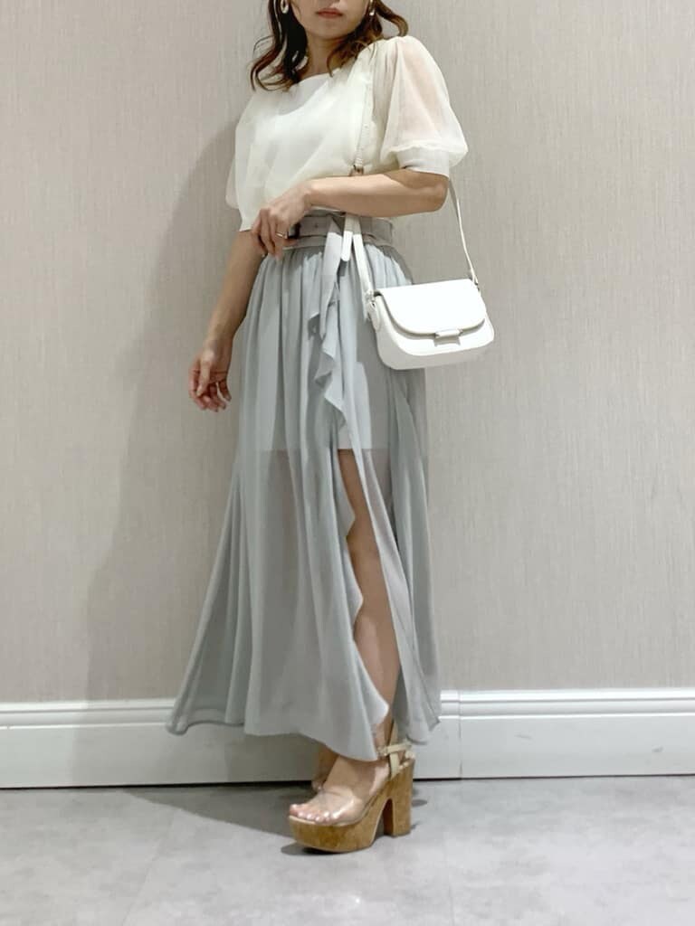 ホワイト系のニット/セーター、ホワイト系のショルダーバッグ、グレー系のスカートを着用したレディースの春コーディネートの3枚目の写真