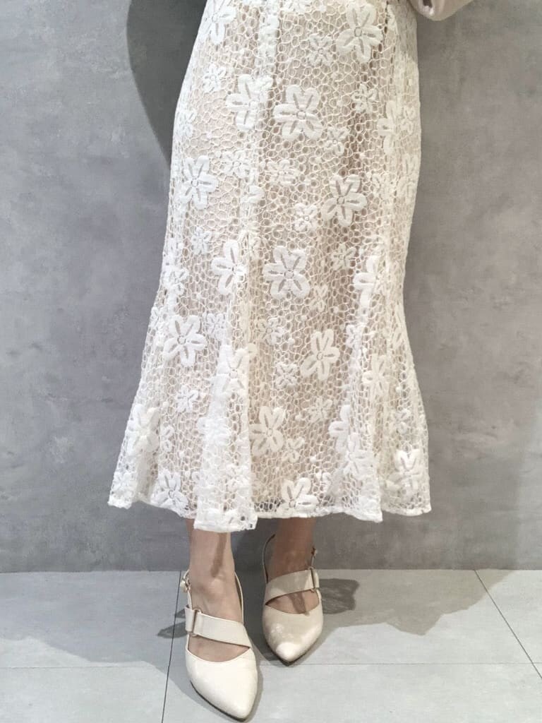 ホワイト系のスカート、ホワイト系のパンプス、ホワイト系のショルダーバッグを着用したレディースの春コーディネートの7枚目の写真