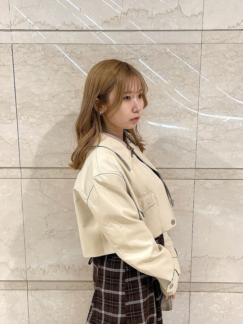 ホワイト系のライダースジャケット、ピンク系のシャツ/ブラウス、ブラウン系のスカートを着用したレディースの冬コーディネートの7枚目の写真