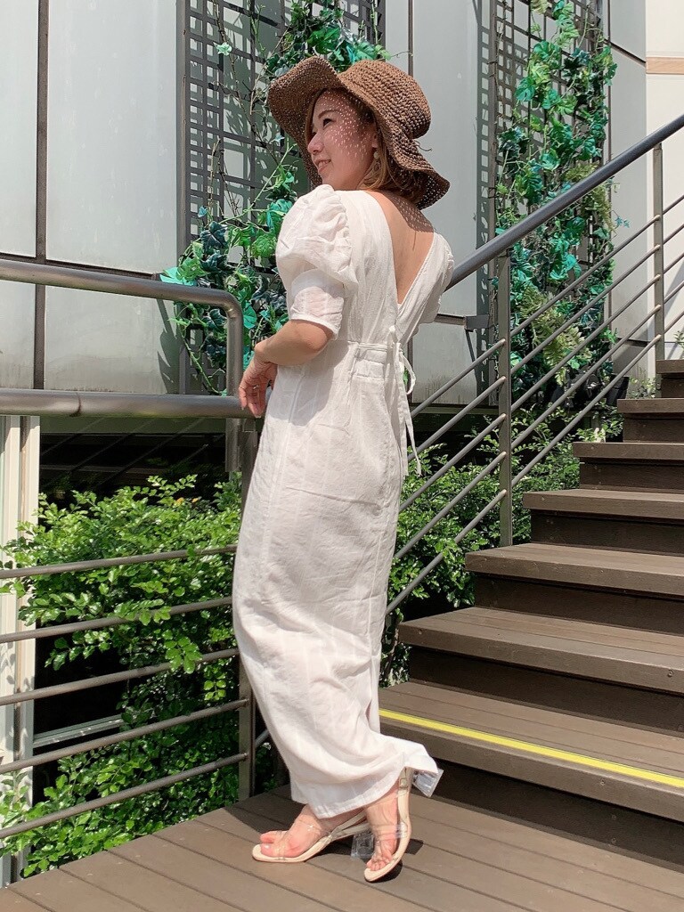 ホワイト系のワンピース、その他のサンダル、ブラウン系のハットを着用したレディースの春コーディネートの4枚目の写真
