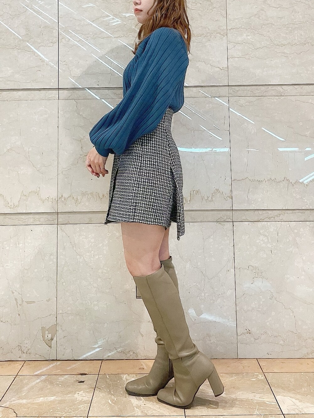 ブルー系のニット/セーター、ブラウン系のブーツ、ブルー系のスカートを着用したレディースの冬コーディネートの4枚目の写真