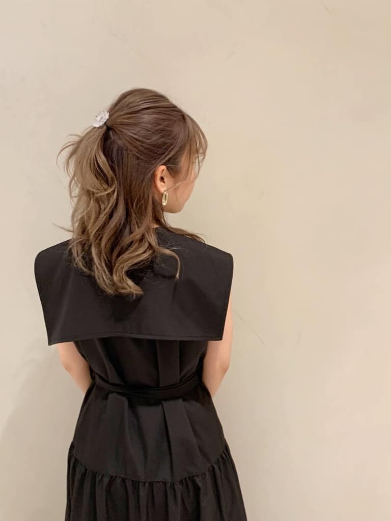 ブルー系のハンドバッグ、ブラック系のワンピース、ブラック系のサンダルを着用したレディースの春コーディネートの5枚目の写真