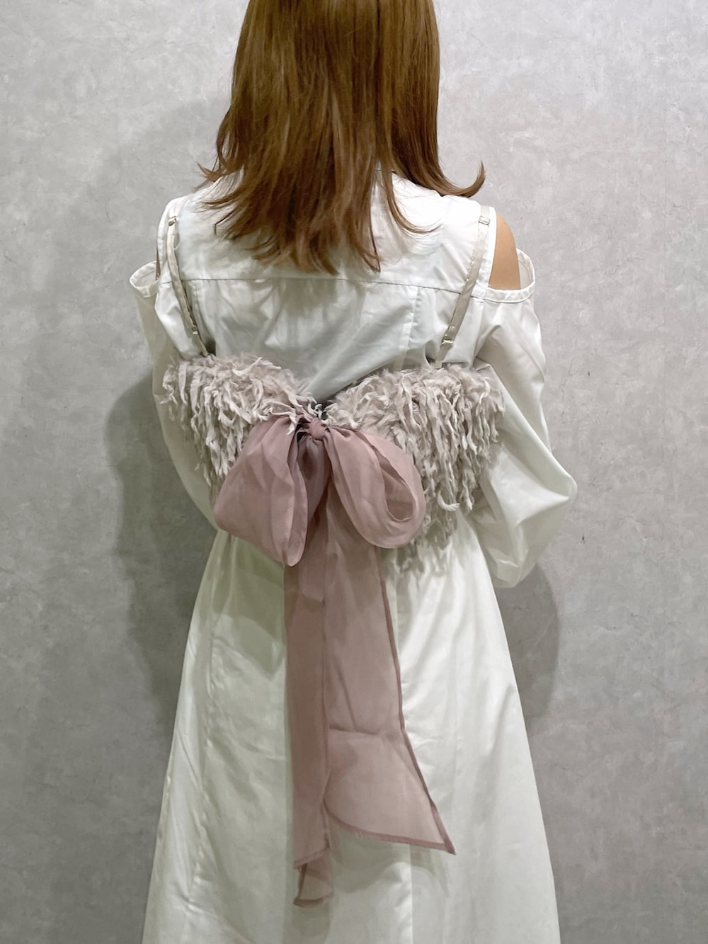 ホワイト系のシャツワンピース、ピンク系のキャミソール、ベージュ系のブーツを着用したレディースの秋コーディネートの7枚目の写真