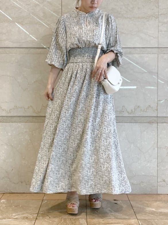 ベージュ系のサンダル、グレー系のワンピースを着用したレディースの春コーディネートの2枚目の写真