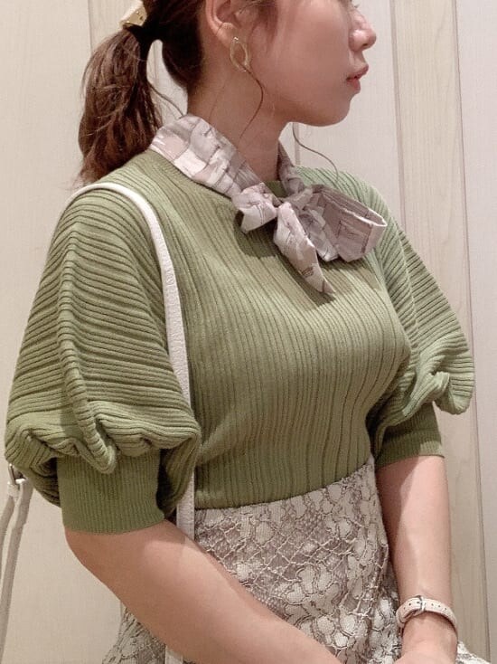 ベージュ系のスカート、ホワイト系のパンプス、グリーン系のニット/セーターを着用したレディースの春コーディネートの5枚目の写真