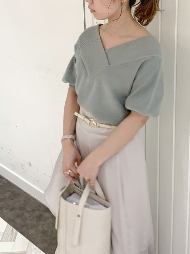 グリーン系のニット/セーター、グレー系のスカート、ホワイト系のローファーを着用したレディースの春コーディネートの5枚目の写真