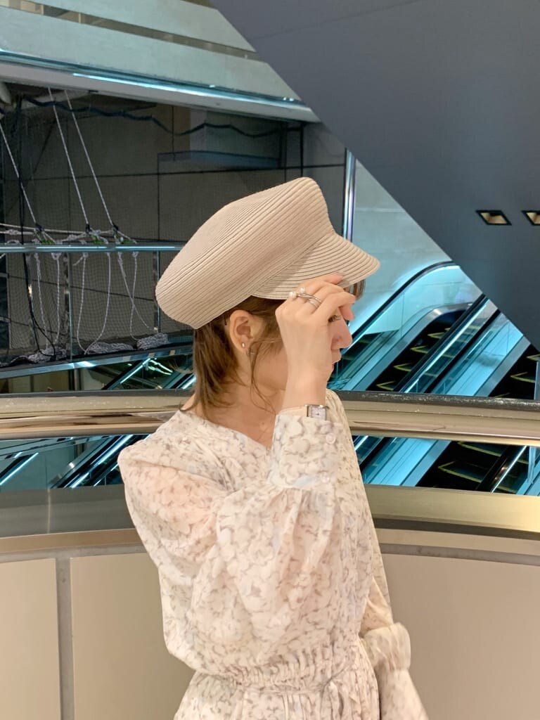 ベージュ系のトレンチコート、オレンジ系のワンピース、ホワイト系のパンプスを着用したレディースの冬コーディネートの9枚目の写真