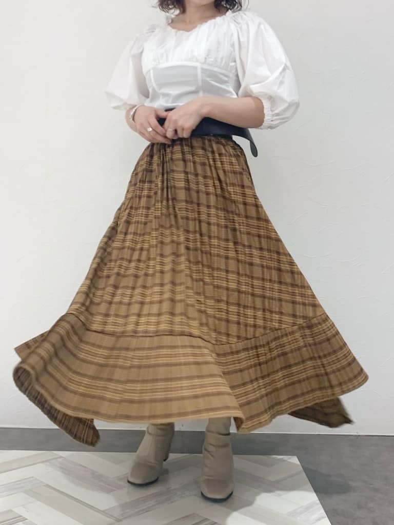 ホワイト系のシャツ/ブラウス、ブラウン系のスカート、ベージュ系のブーツを着用したレディースの夏コーディネートの10枚目の写真
