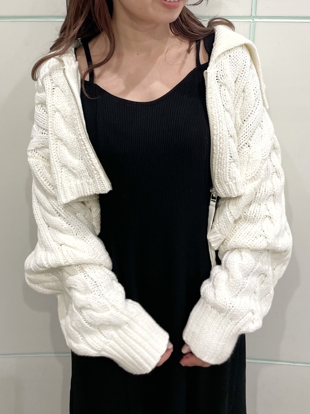 ブラック系のワンピース、ホワイト系のカーディガン/ボレロ、ブラック系のブーツを着用したレディースの秋コーディネートの7枚目の写真