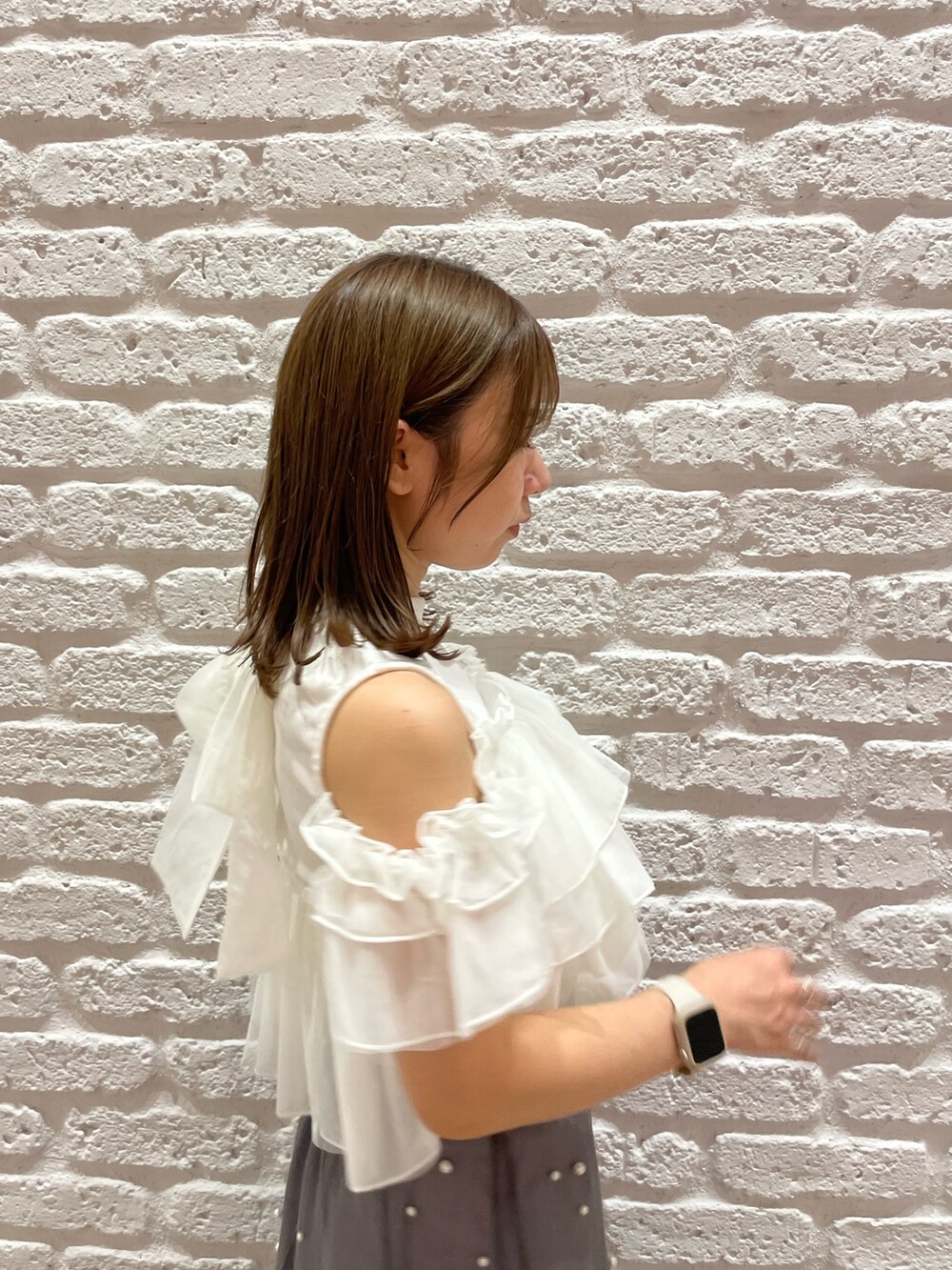 ホワイト系のTシャツ/カットソー、ブラック系のパンプス、ブラック系のハンドバッグを着用したレディースの夏コーディネートの6枚目の写真