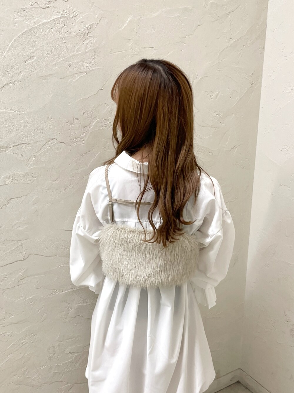 ホワイト系のワンピース、ベージュ系のベスト、イエロー系のハンドバッグを着用したレディースの夏コーディネートの7枚目の写真