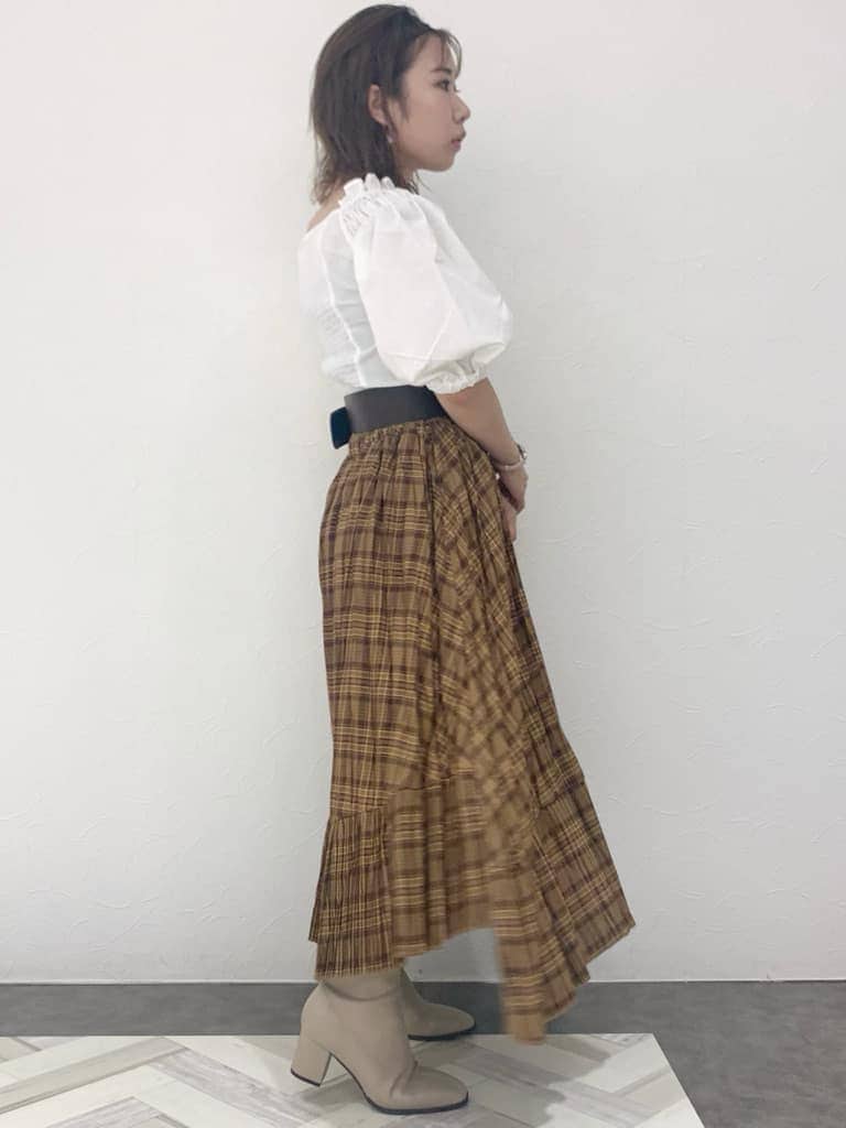 ホワイト系のシャツ/ブラウス、ブラウン系のスカート、ベージュ系のブーツを着用したレディースの夏コーディネートの3枚目の写真