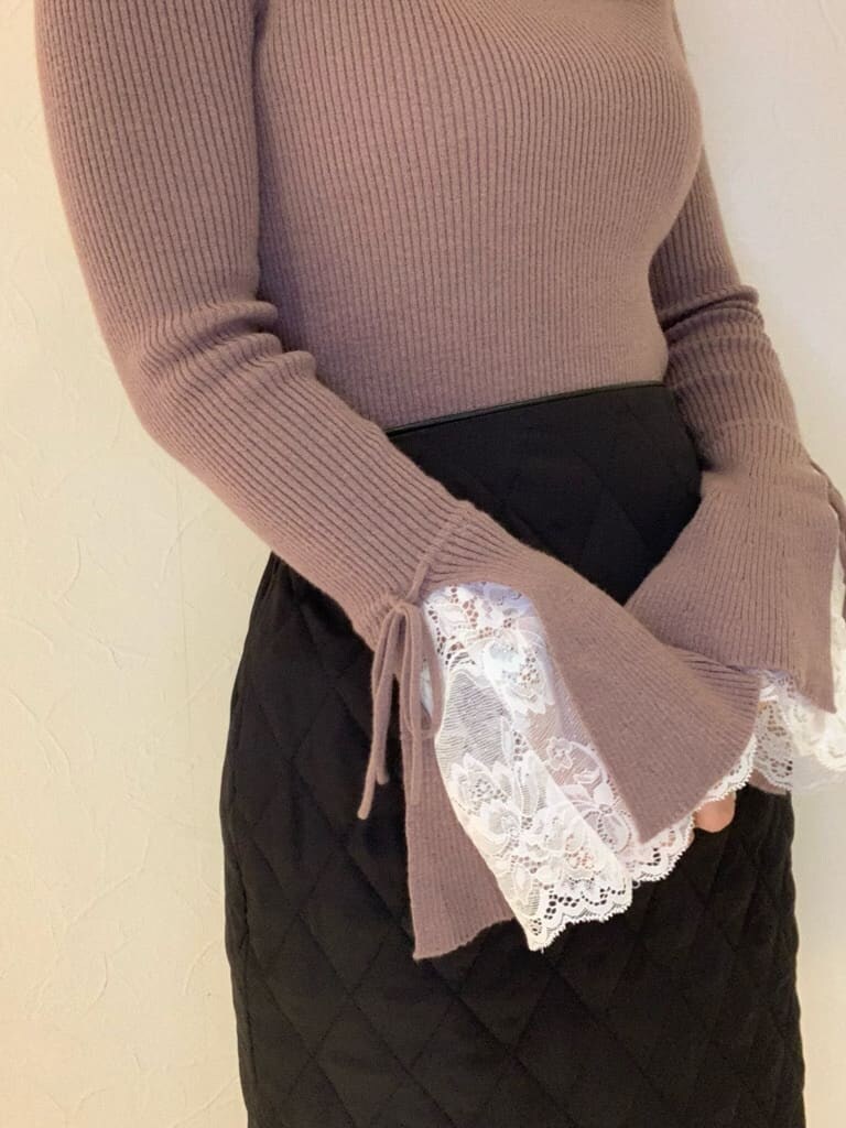 ブラック系のスカート、ブラック系のブーツ、ピンク系のニット/セーターを着用したレディースの秋コーディネートの2枚目の写真