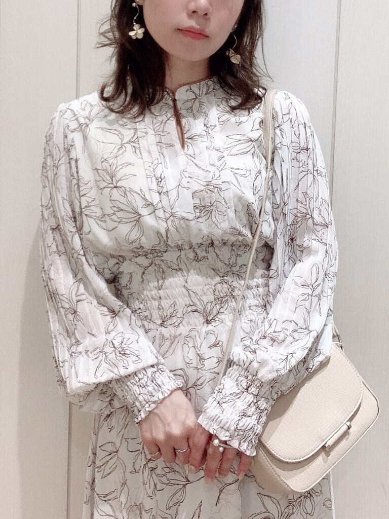 ホワイト系のワンピース、ベージュ系のパンプス、ベージュ系のショルダーバッグを着用したレディースの冬コーディネートの5枚目の写真