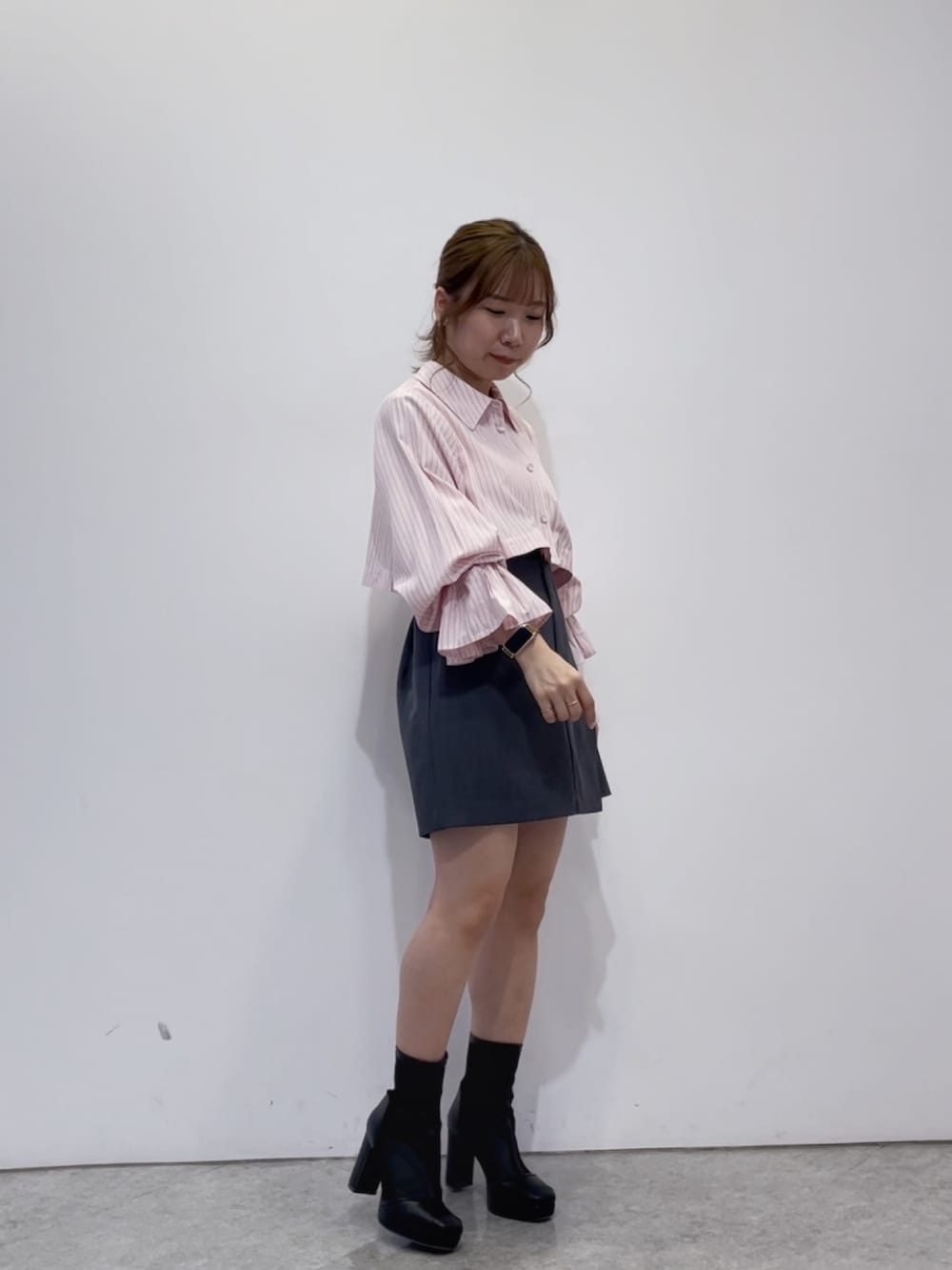ピンク系のワンピース、グレー系のスカート、ブラック系のブーツを着用したレディースの春コーディネートの4枚目の写真