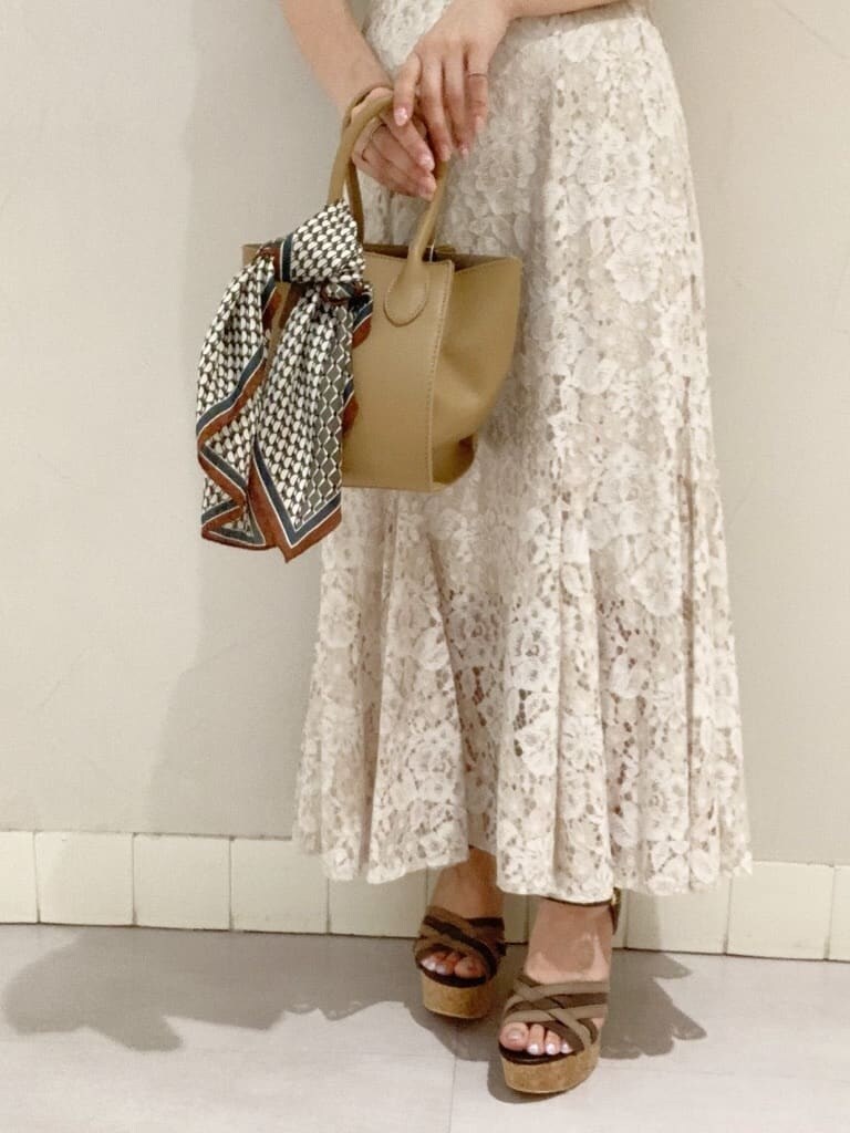 ベージュ系のハンドバッグ、その他のサンダル、グレー系のTシャツ/カットソーを着用したレディースの春コーディネートの4枚目の写真