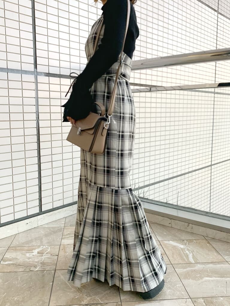 ブラック系のブーツ、グレー系のジャンパースカート、ブラック系のニット/セーターを着用したレディースの冬コーディネートの7枚目の写真