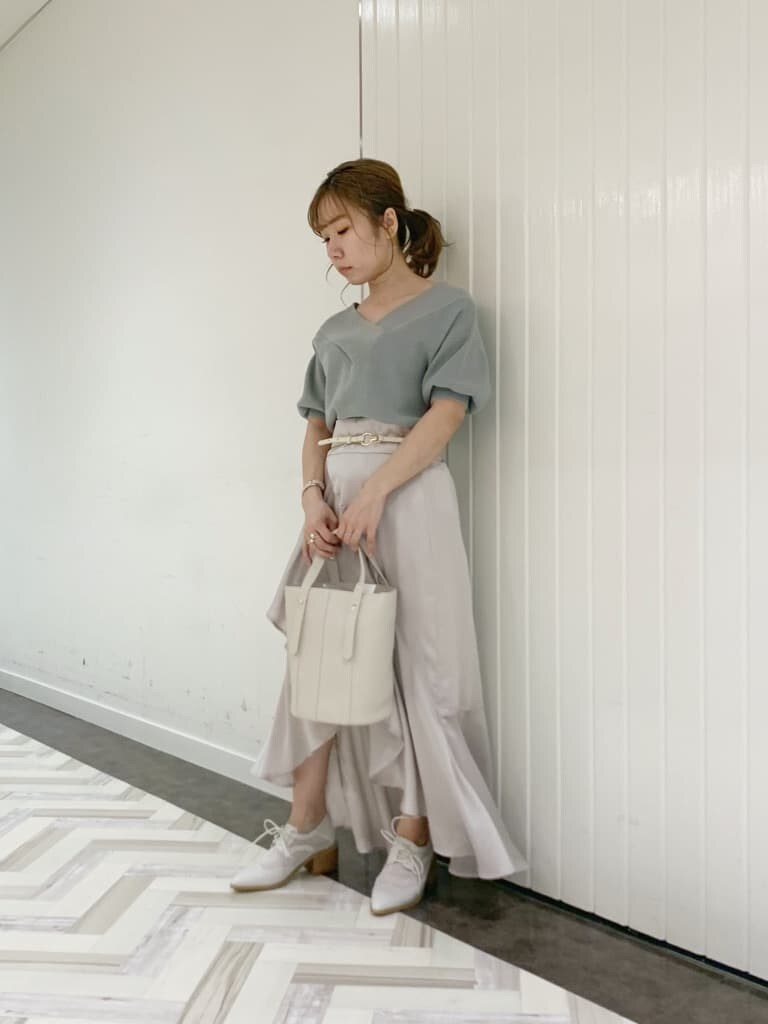 グリーン系のニット/セーター、グレー系のスカート、ホワイト系のローファーを着用したレディースの春コーディネートの3枚目の写真