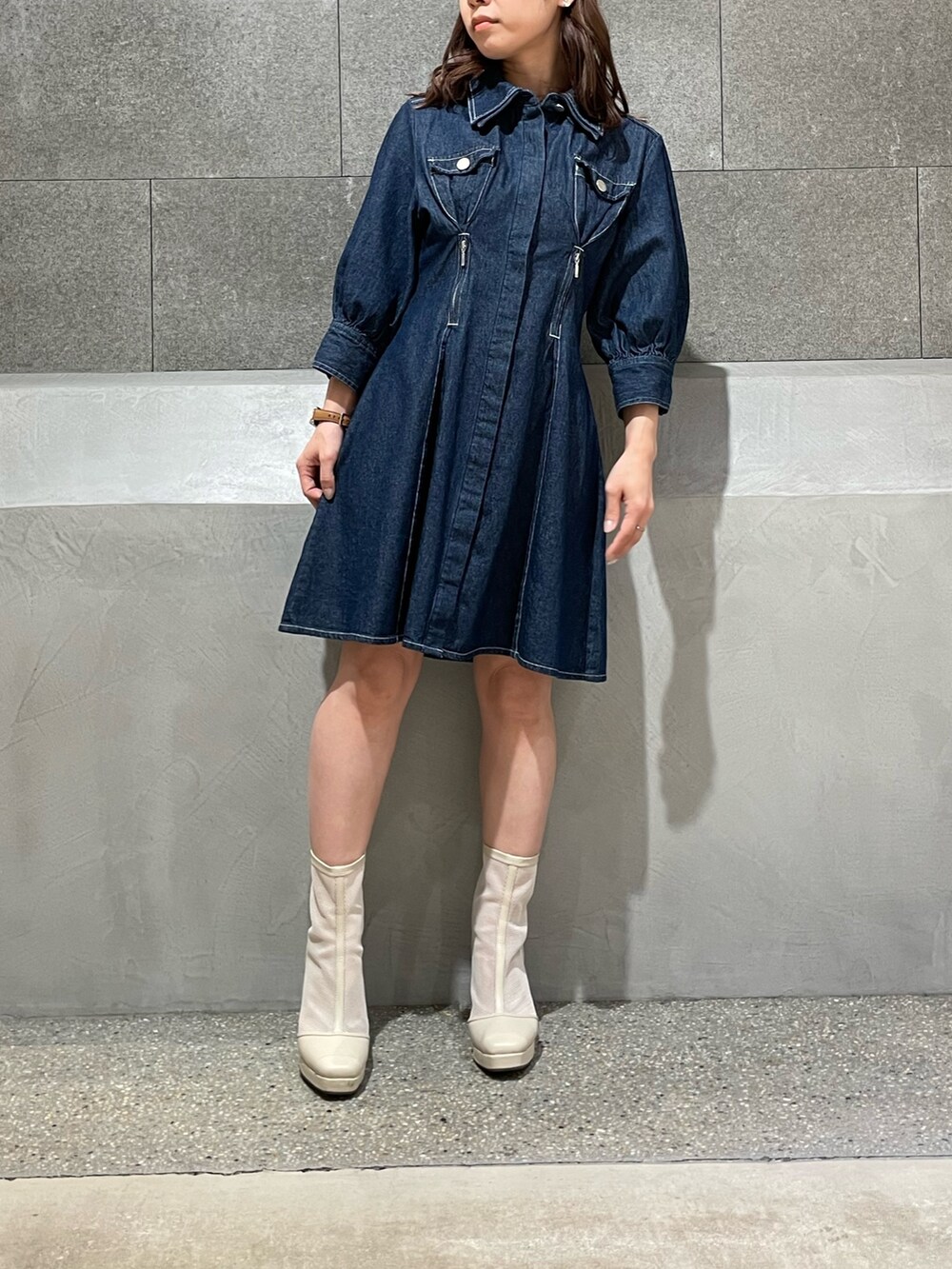 ブルー系のシャツワンピース、ホワイト系のブーツを着用したレディースの冬コーディネートの2枚目の写真