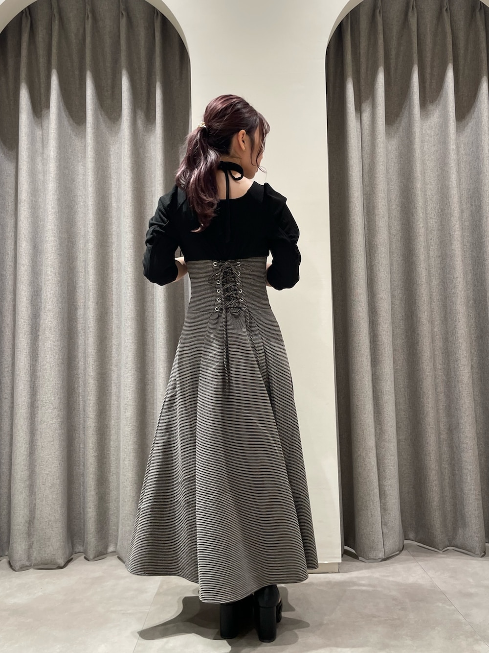 ブラック系のワンピース、ブラック系のパンプスを着用したレディースの秋コーディネートの3枚目の写真