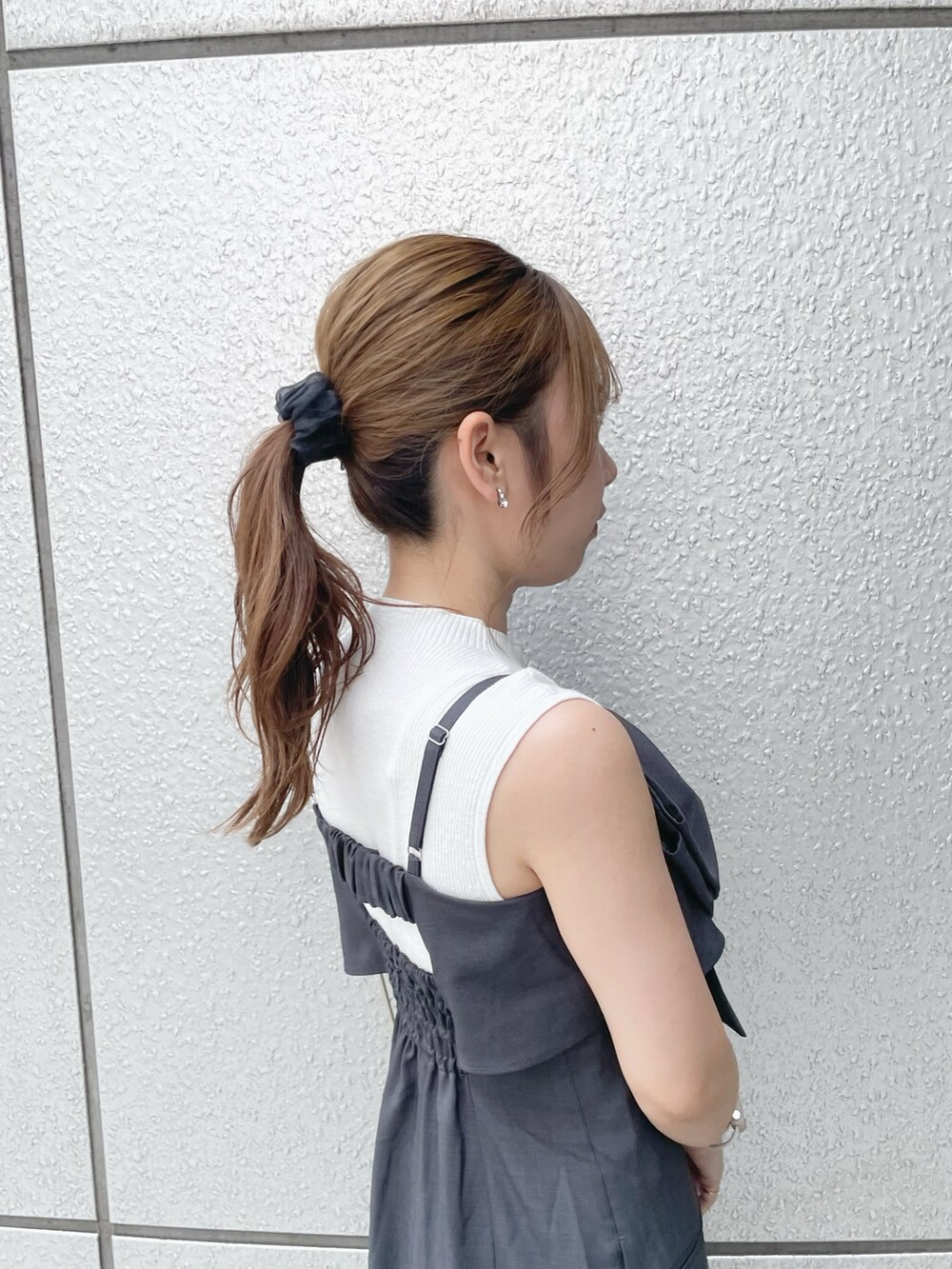 ホワイト系のニット/セーター、グレー系のワンピース、ブラック系のサンダルを着用したレディースの夏コーディネートの8枚目の写真