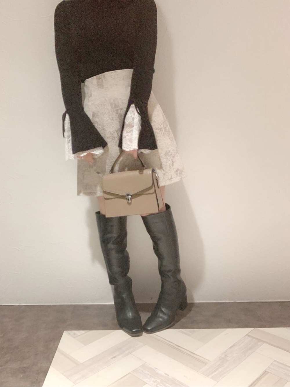 ベージュ系のスカート、ブラック系のブーツ、ブラック系のニット/セーターを着用したレディースの秋コーディネートの5枚目の写真