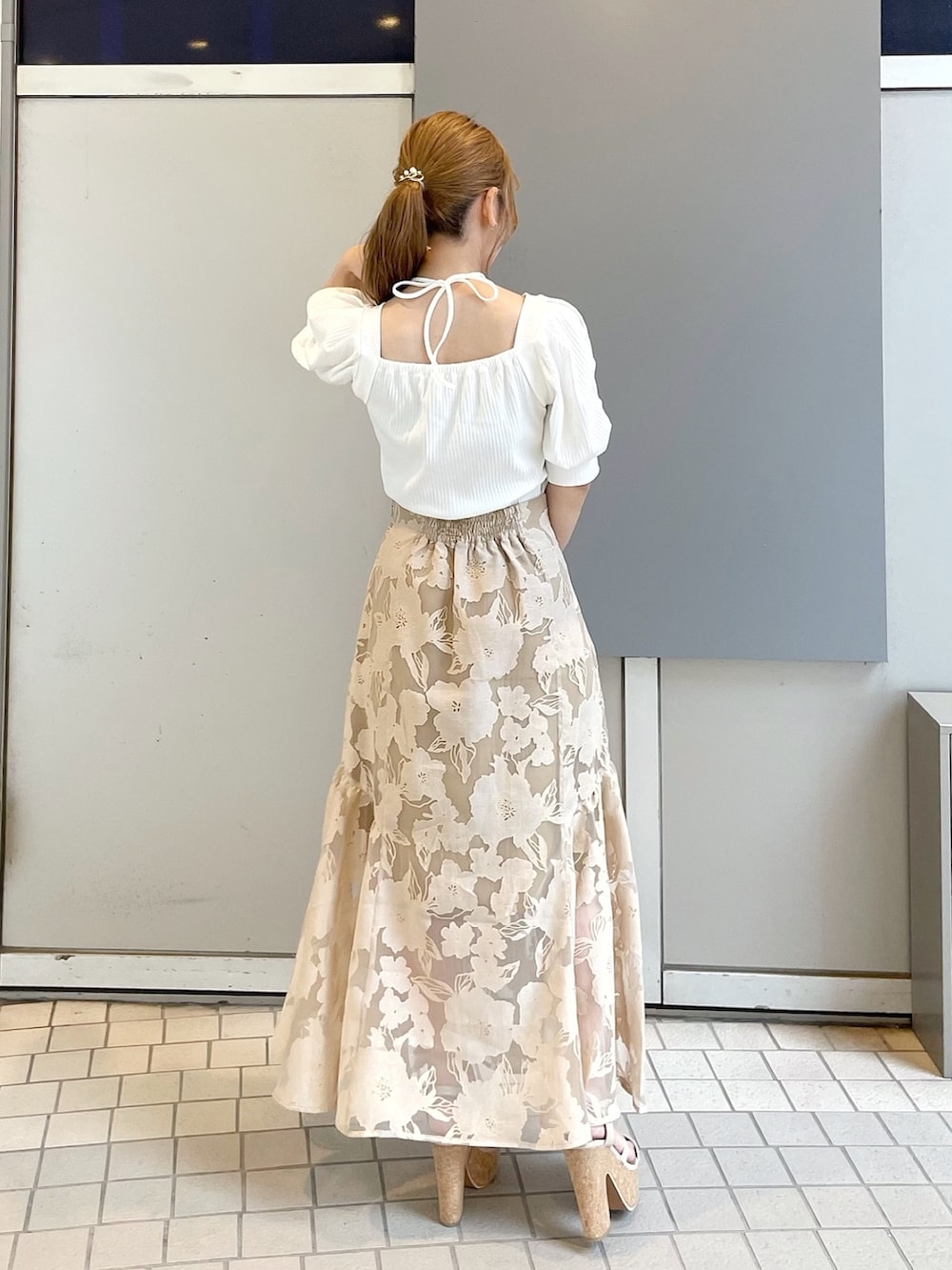 ホワイト系のサンダル、イエロー系のハンドバッグ、ホワイト系のTシャツ/カットソーを着用したレディースの夏コーディネートの4枚目の写真