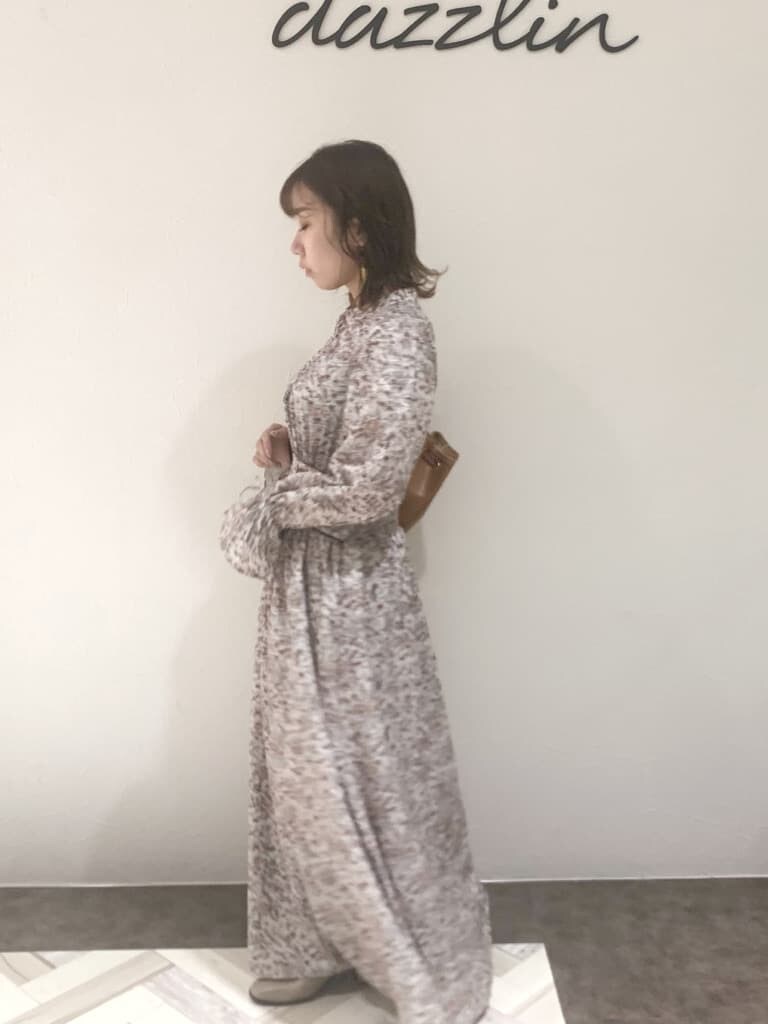 ブラウン系のワンピース、ベージュ系のブーツ、ブラウン系のバックパック/リュックを着用したレディースの秋コーディネートの5枚目の写真