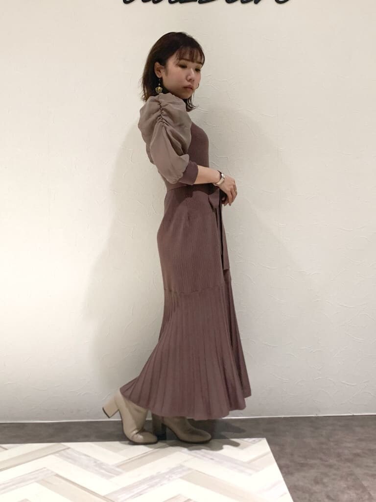 ブラウン系のワンピース、グレー系のトレンチコート、ベージュ系のハンドバッグを着用したレディースの秋コーディネートの7枚目の写真