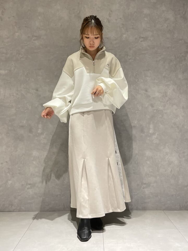 ベージュ系のスカート、ブラック系のブーツ、ベージュ系のTシャツ/カットソーを着用したレディースの秋コーディネートの3枚目の写真