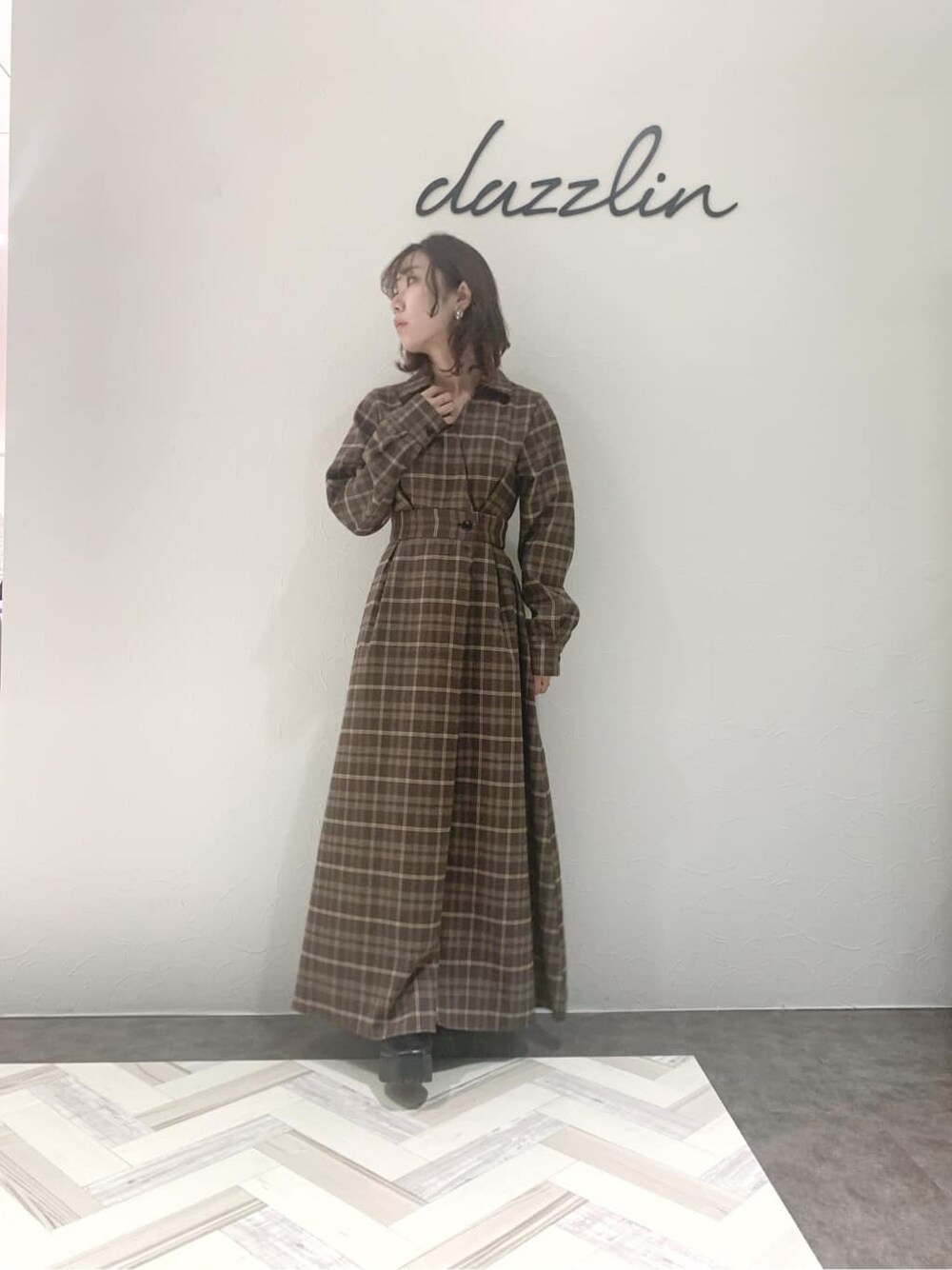 ブルー系のチェスターコート、ブラック系のブーツ、その他のワンピースを着用したレディースの秋コーディネートの2枚目の写真