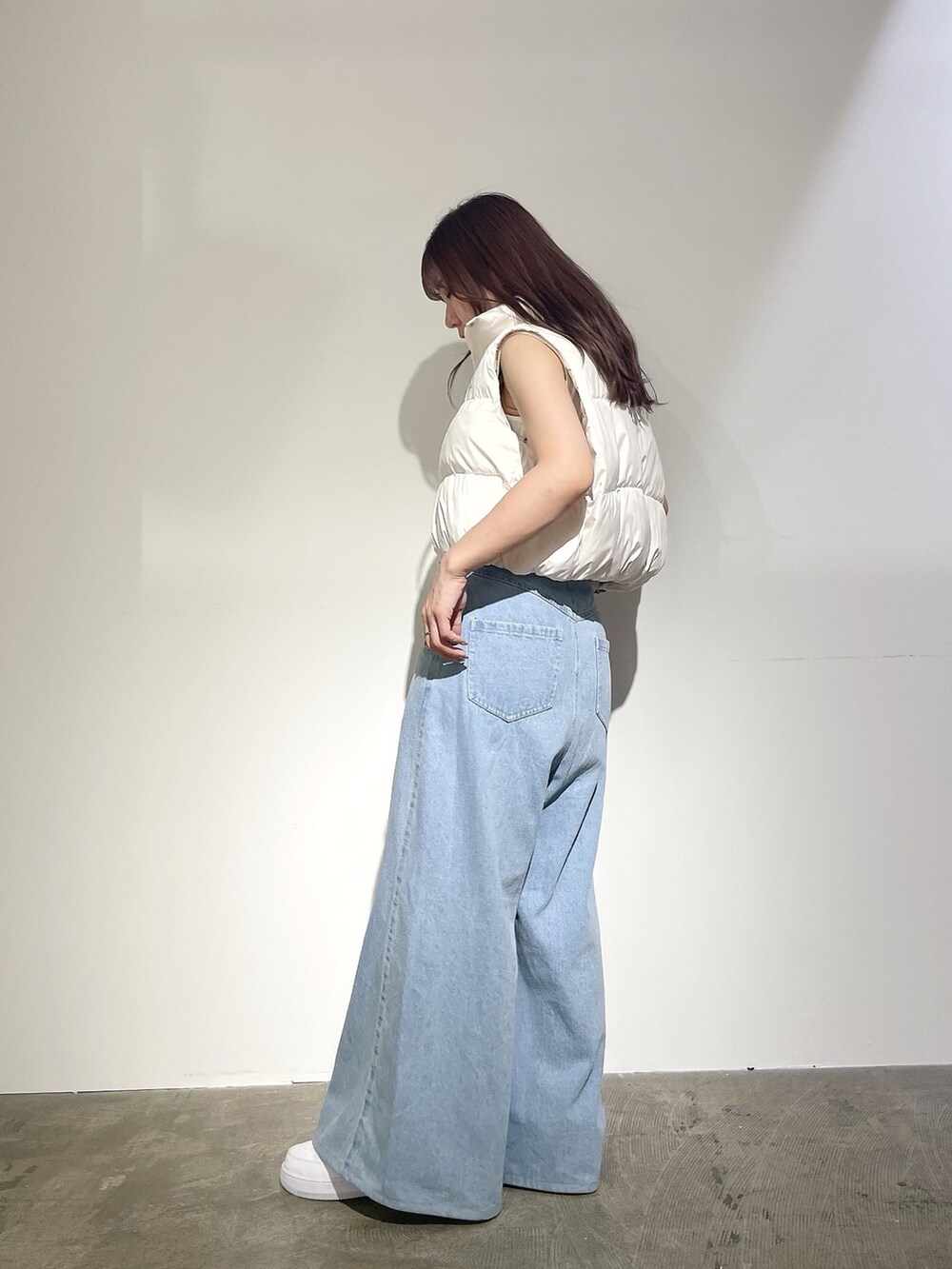 ブルー系のデニムパンツ、ホワイト系のニット/セーター、ホワイト系のベストを着用したレディースの夏コーディネートの3枚目の写真