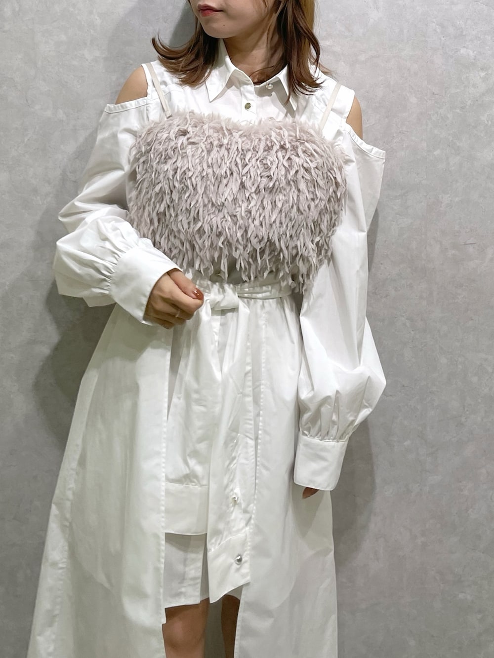 ホワイト系のシャツワンピース、ピンク系のキャミソール、ベージュ系のブーツを着用したレディースの秋コーディネートの8枚目の写真