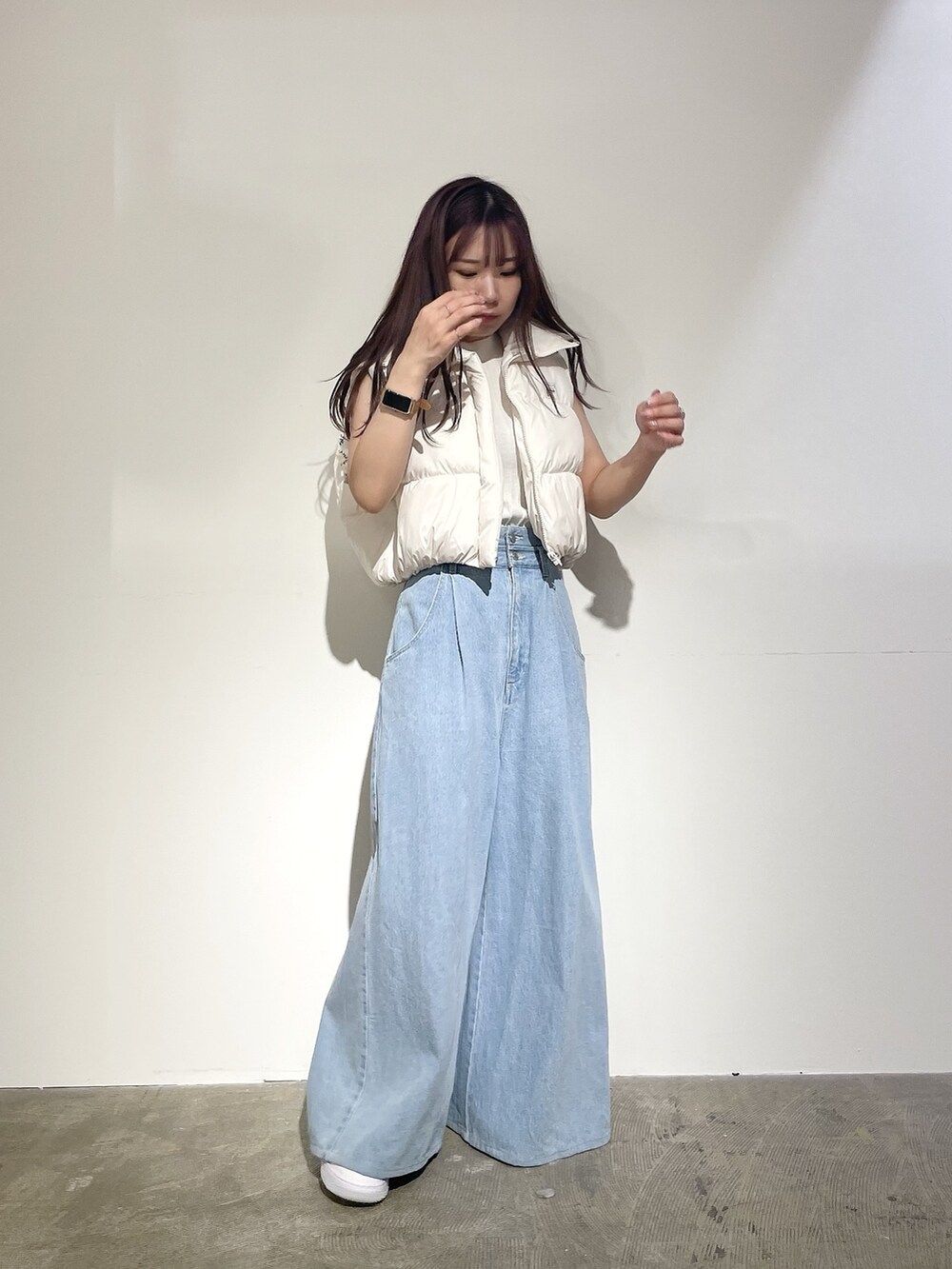 ブルー系のデニムパンツ、ホワイト系のニット/セーター、ホワイト系のベストを着用したレディースの夏コーディネートの4枚目の写真