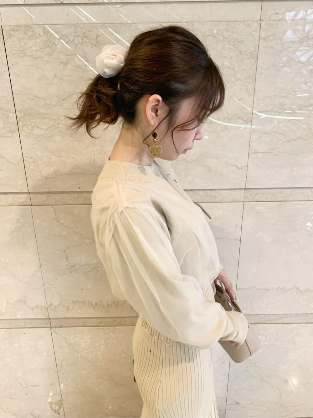 ブラック系のブーツ、ブラウン系のチェスターコート、ベージュ系のワンピースを着用したレディースの冬コーディネートの3枚目の写真