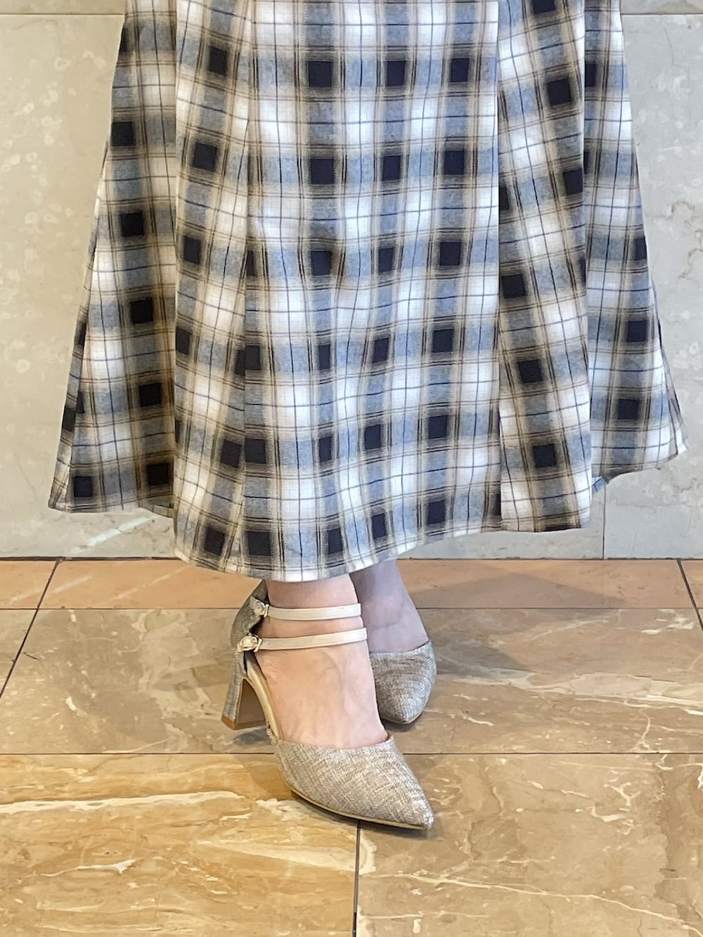 イエロー系のワンピース、グレー系のパンプスを着用したレディースの冬コーディネートの8枚目の写真