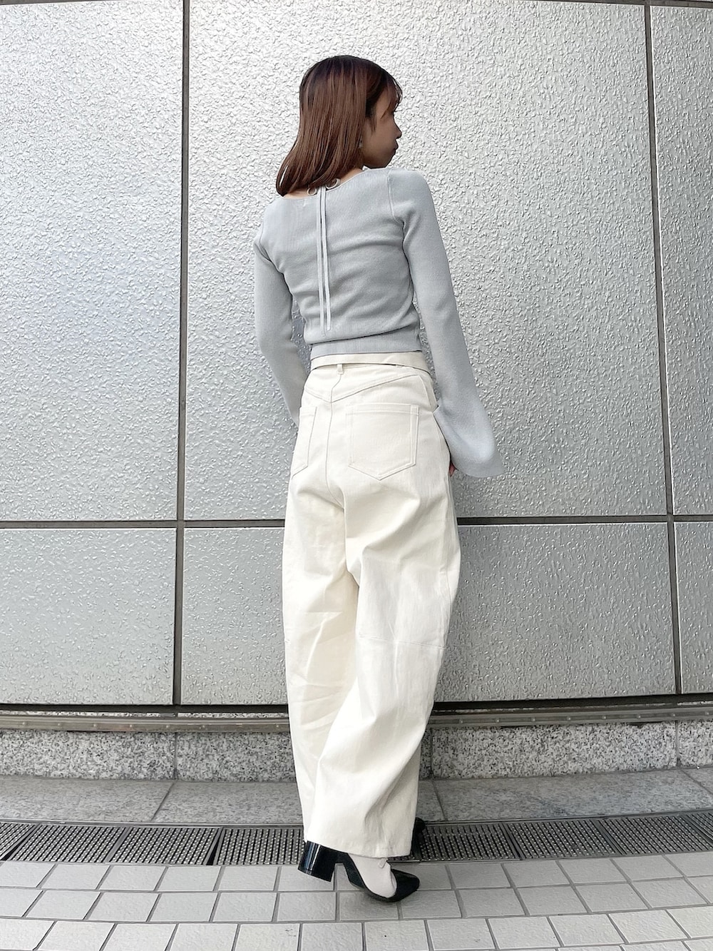 グレー系のニット/セーター、ホワイト系のデニムパンツ、その他のパンプスを着用したレディースの冬コーディネートの4枚目の写真