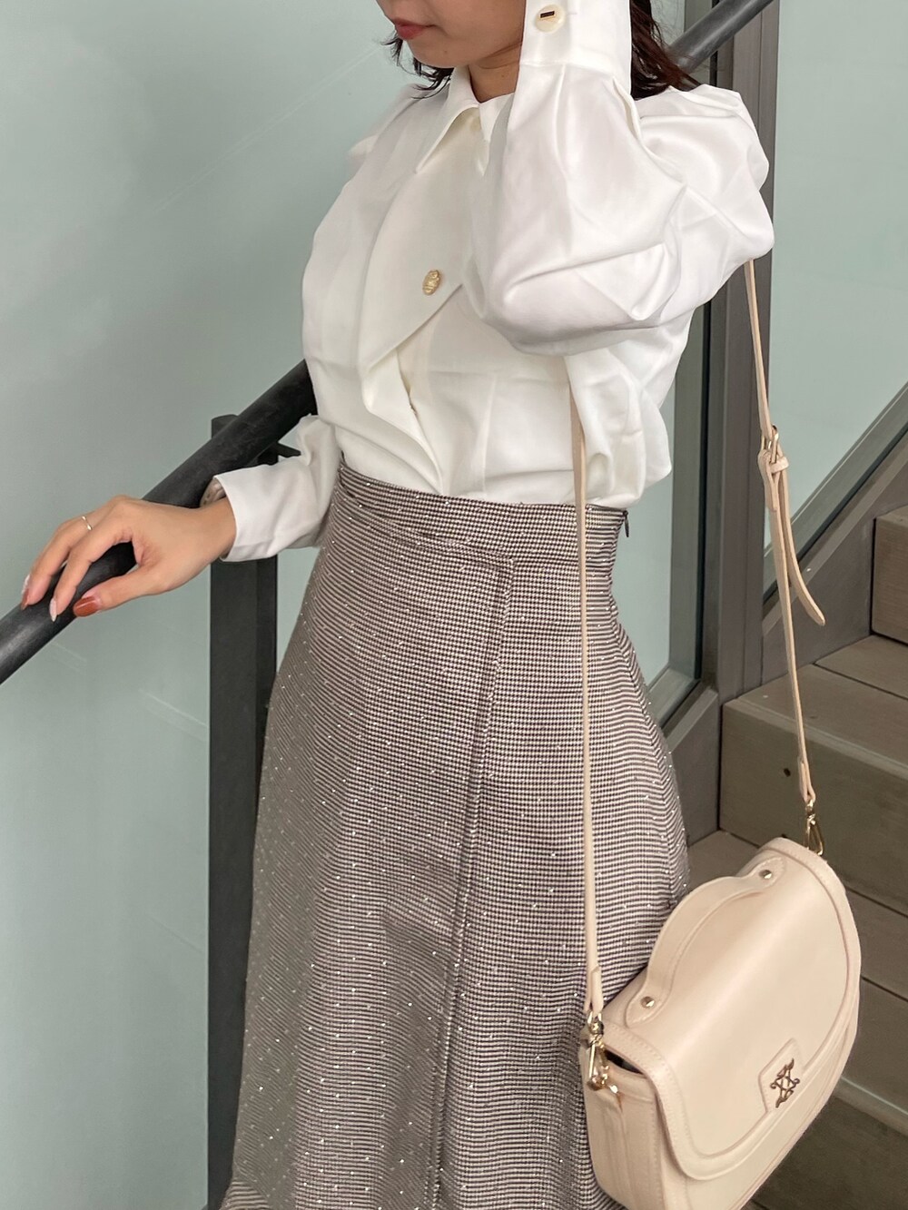 ホワイト系のシャツ/ブラウス、ブラウン系のスカート、ベージュ系のブーツを着用したレディースの秋コーディネートの5枚目の写真