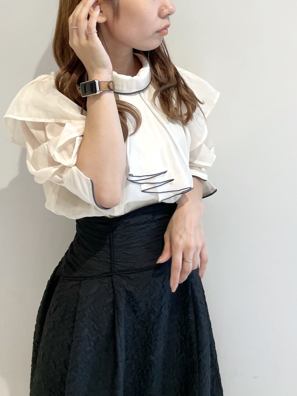 ホワイト系のシャツ/ブラウス、ブラック系のスカート、ブラック系のパンプスを着用したレディースの夏コーディネートの5枚目の写真