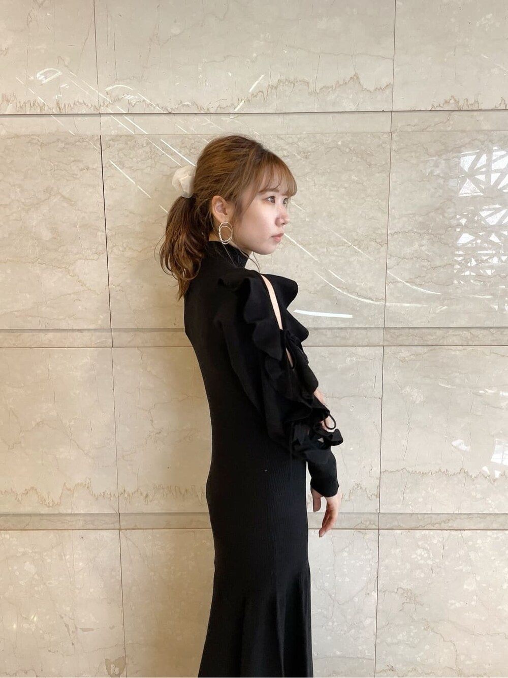 ベージュ系のブーツ、ブラック系のワンピース、ゴールド系のピアス（両耳用）を着用したレディースの秋コーディネートの6枚目の写真