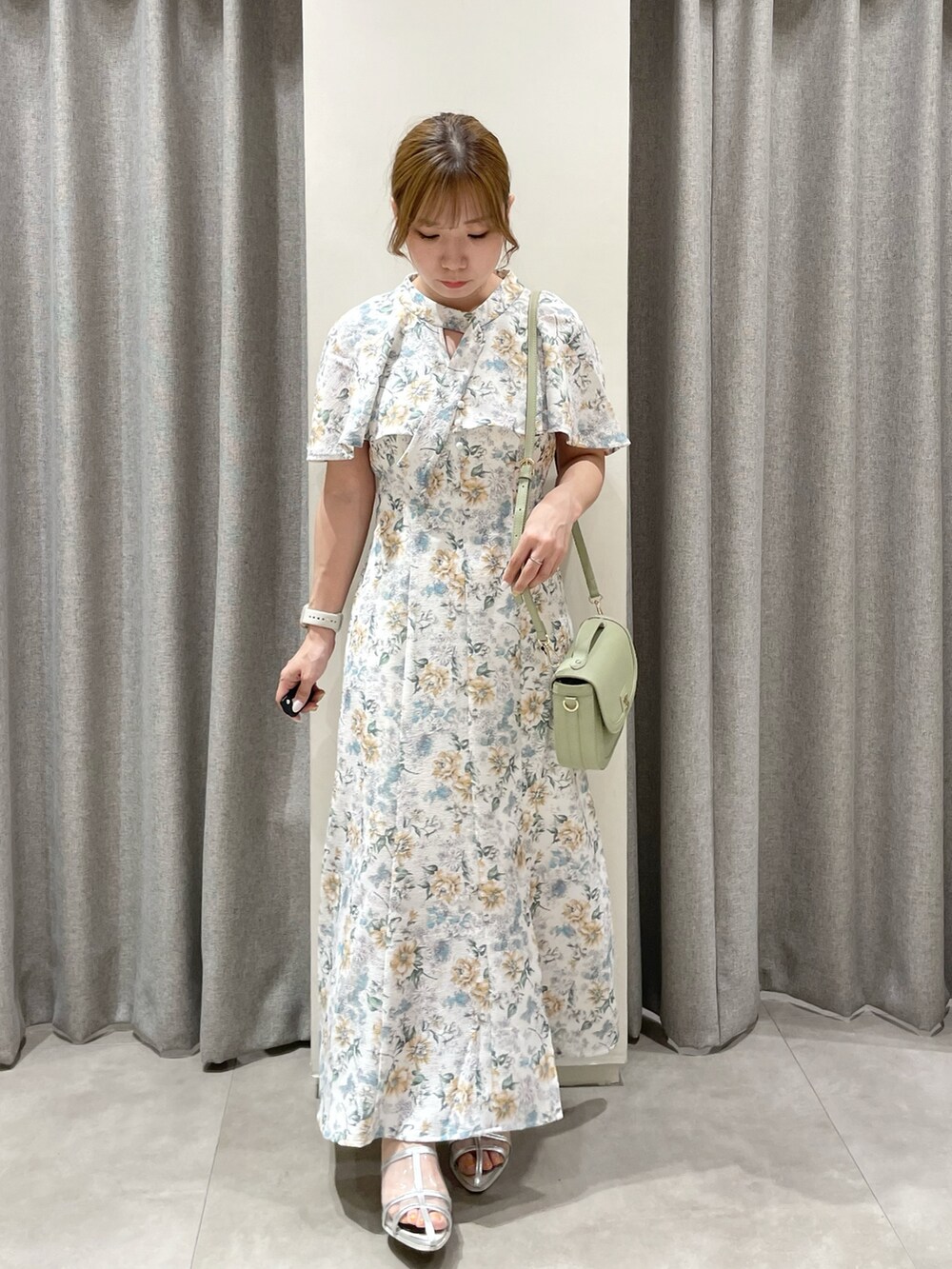 グリーン系のワンピース、グリーン系のハンドバッグ、シルバー系のパンプスを着用したレディースの夏コーディネートの3枚目の写真