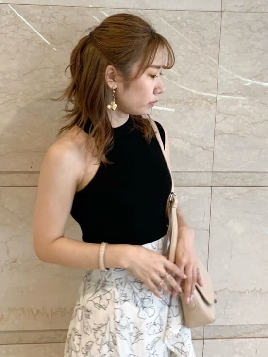 ブラック系のサンダル、ベージュ系のショルダーバッグ、ホワイト系のスカートを着用したレディースの春コーディネートの6枚目の写真